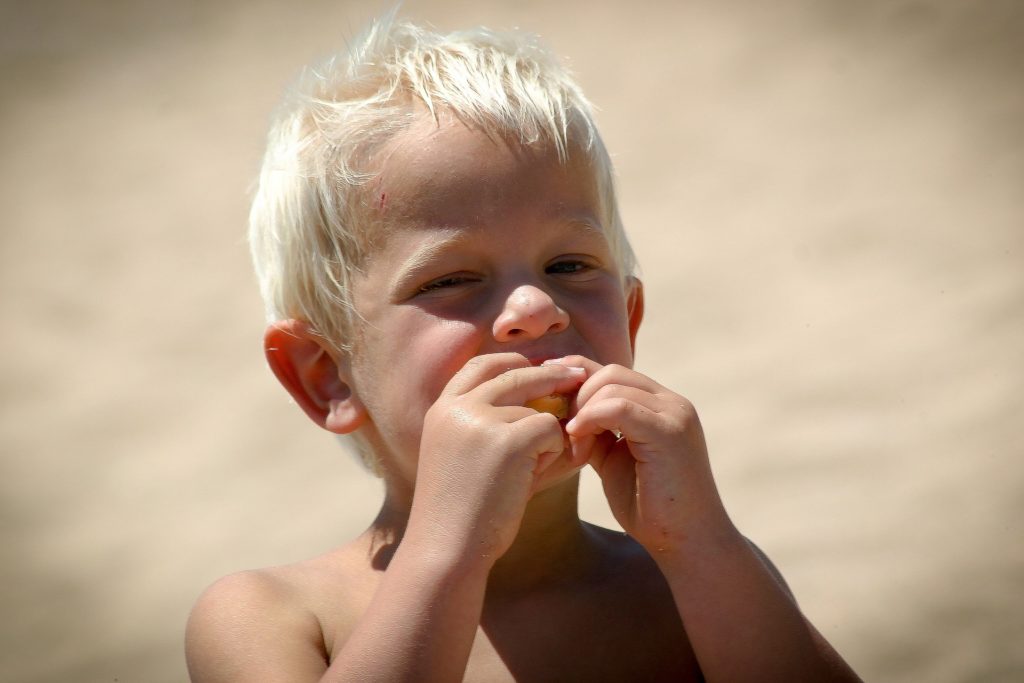 child eat on the beach